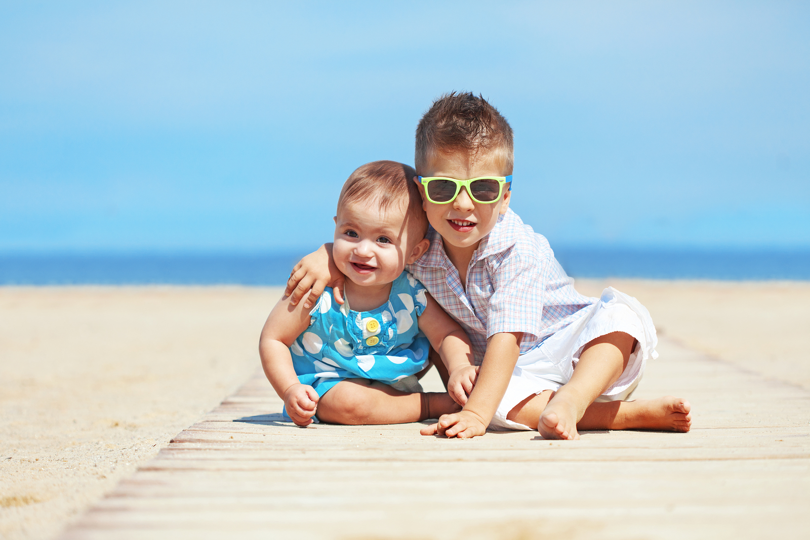 Portrait of kids resting on the beach in summer